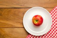 木桌餐盘里的红苹果图片