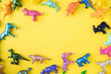 玩具恐龙黄色背景图片素材