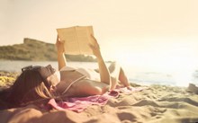 躺在沙滩上看书的美女图片下载