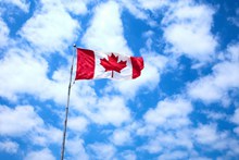 蓝天下飘扬加拿大国旗图片下载