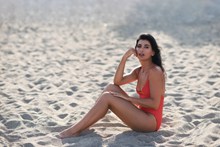 穿着泳装的美女坐在沙滩上图片素材