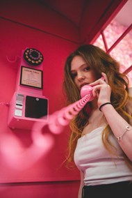 粉色电话亭打电话的美女图片下载