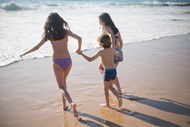 三个孩子在沙滩上玩乐图片下载