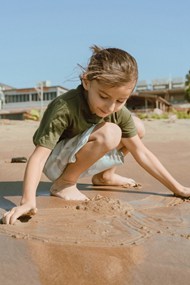 小女孩在沙滩上玩沙子图片素材