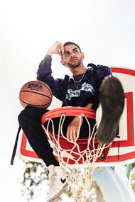 男子坐在篮球框架高清图片