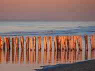 黄昏大海木柱防护堤图片