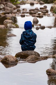 小男孩坐在河边背影高清图片