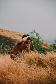 写真师帅哥站在枯草丛拍照图片下载