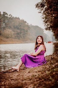 坐在河边的紫色连衣裙美女高清图片