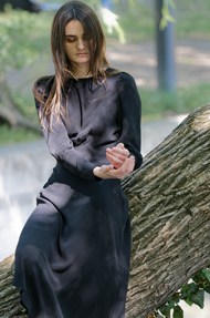 坐在树干上的黑色连衣裙美女图片下载
