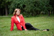 坐在公园草地上的红色西装美女精美图片