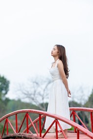 站在红色小桥上的白裙美女摄影图片