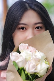 亚洲美女手持一束白玫瑰花束图片
