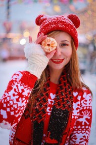 冬天手持橘子开心快乐的戴帽美女高清图片