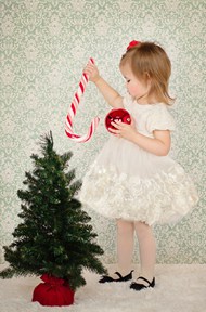 小女孩站在圣诞树旁玩耍精美图片
