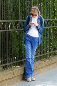 牛仔裤美女戴墨镜站在街边看手机图片