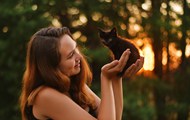 欧美美女手里捧着只小黑猫高清图片