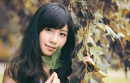 亚洲手持树叶的清纯美女图片下载