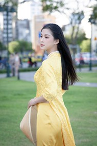 亚洲草地黄色奥黛美女摄影写真图片