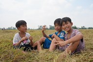 坐在田野稻草上的乡村孩童写真图片