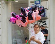 街拍街头卖气球的女人高清图片