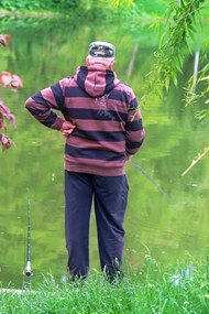 欧美老人站在河边钓鱼背影高清图片