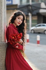 站在街头手捧花束的红裙美女高清图片